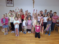 Kinderferienpogramm 2026 - die Kinder mit dem gebastelten Windspiel und Herz